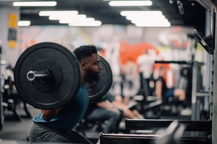 En mann som tar knebøy