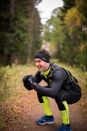 En gutt som gjør knebøy utendørs med vektvest