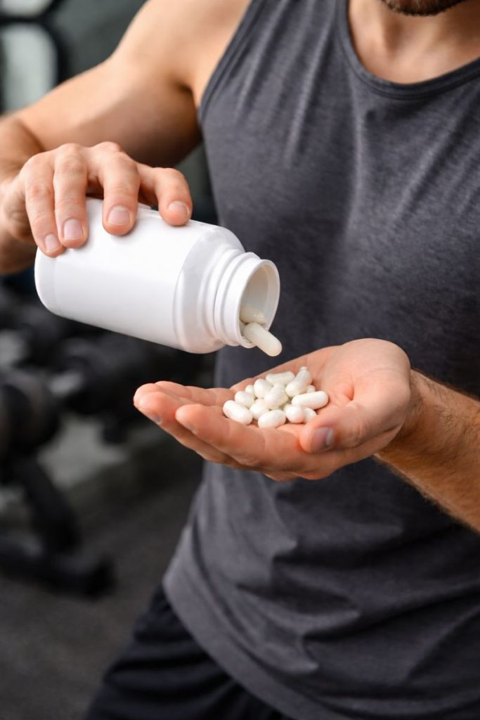 En mann som holder kapsler i hånden